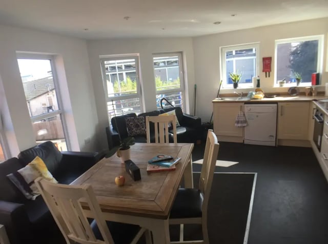 Living room with sofa dining table and kitchen at The Student Block in Loughborough Student Accommodation