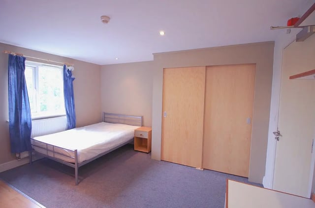 Bed nightstand closet and sliding doors bedroom at Kingfisher Halls in Loughborough Student Accommodation