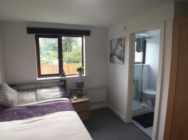 Bed nightstand window Buddha statue and bathroom bedroom at Kingfisher Halls in Loughborough Student Accommodation