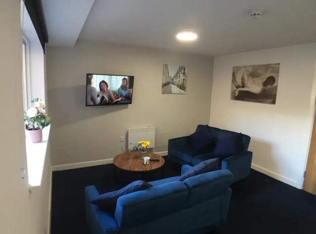 Two blue sofas television coffee table living room at Kingfisher Halls in Loughborough Student Accommodation