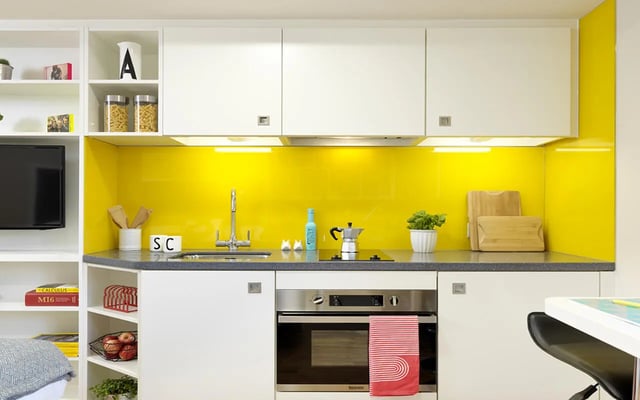 Compact modern kitchen with yellow backsplash kitchen at Student Castle York in York Student Accommodation