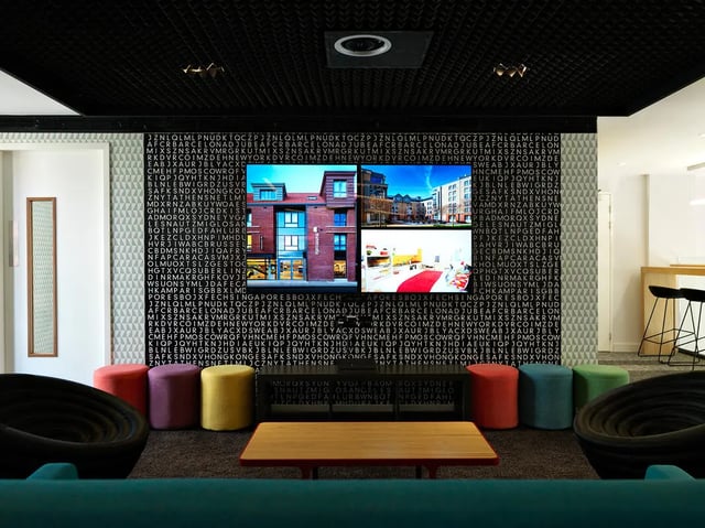Four stools near TV on text wall lounge at Student Castle York in York Student Accommodation