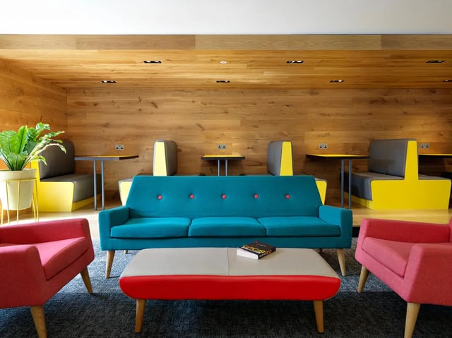 Teal sofa pink chairs booth seating living room at Student Castle York in York Student Accommodation