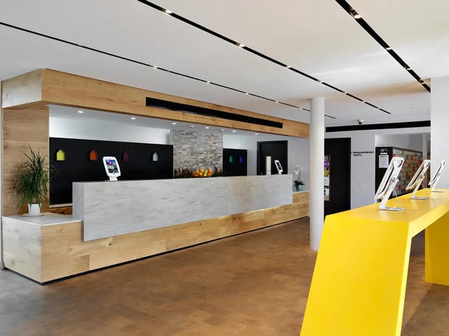 Reception desk with tablets and a yellow counter lobby at Student Castle York in York Student Accommodation