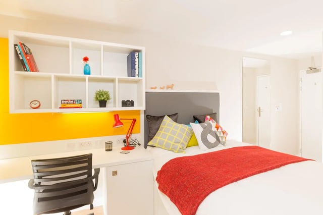 Bed desk and shelf with books and lamp bedroom at Student Castle York in York Student Accommodation