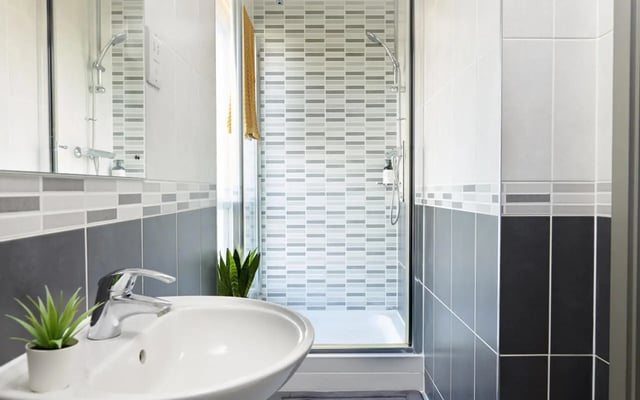 Sink shower plants mirror tiled bathroom at Student Castle Lincoln in Lincoln Student Accommodation