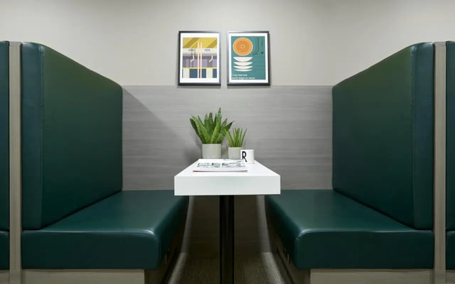 Green booths and white table seating area at Student Castle Lincoln in Lincoln Student Accommodation