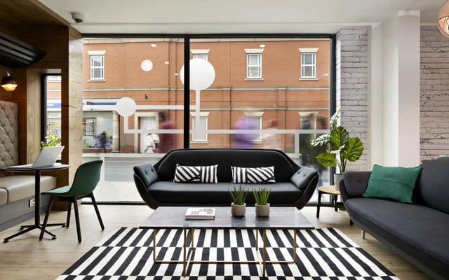 Sofa coffee table rug and plant living room at Student Castle Lincoln in Lincoln Student Accommodation