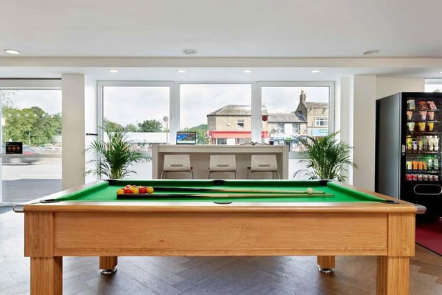 Pool table with balls cues vending machine and chairs area at Saw Mill in Huddersfield Student Accommodation