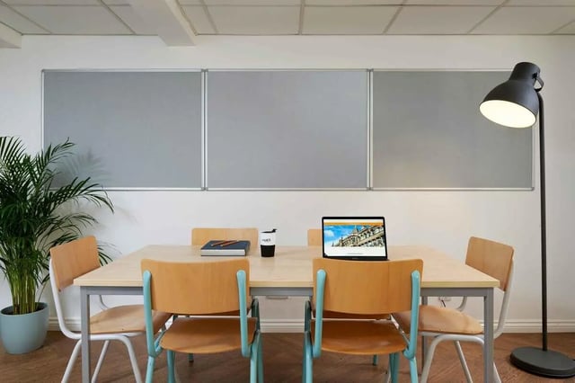 Table chairs laptop plant and whiteboard study area at Snow Island in Huddersfield Student Accommodation