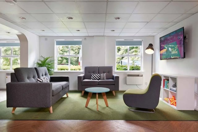 Sofas coffee table chair TV bookshelf living room at Snow Island in Huddersfield Student Accommodation