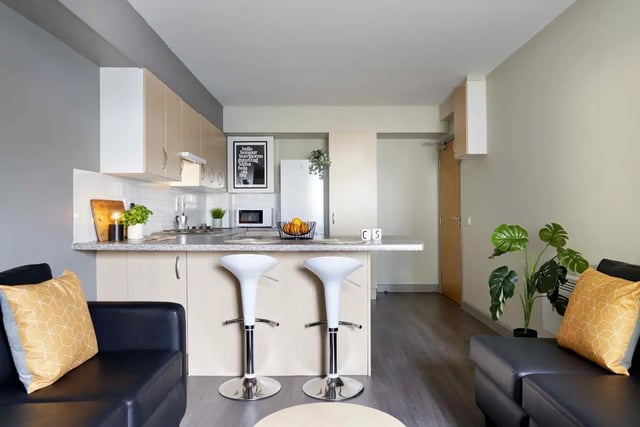 Kitchen with bar stools couch pillows and plant kitchen at Alexandra Works in Plymouth Student Accommodation
