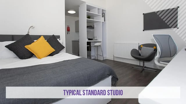 Bed with cushions kitchen small bar chairs studio bedroom at Kensington House in Birmingham Student Accommodation
