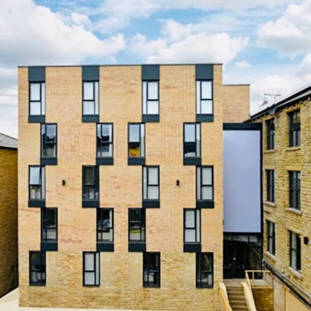 Modern brick building with many windows exterior at The Courtyard Block A in Huddersfield Student Accommodation