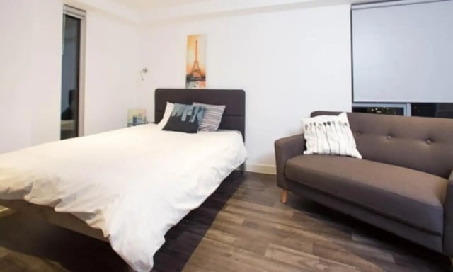 Bed sofa with pillows and artwork Bedroom living room at Edge Apartments - Leicester in Leicester Student Accommodation