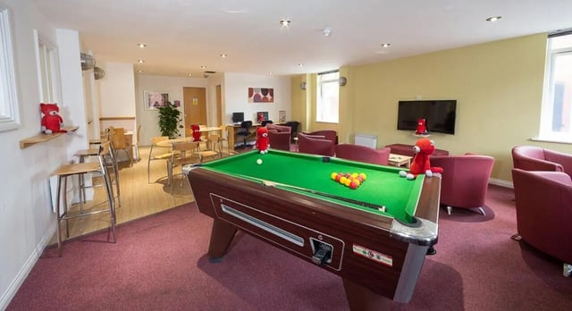 Pool table red chairs and tables common room at Q3 Apartments in Manchester Student Accommodation