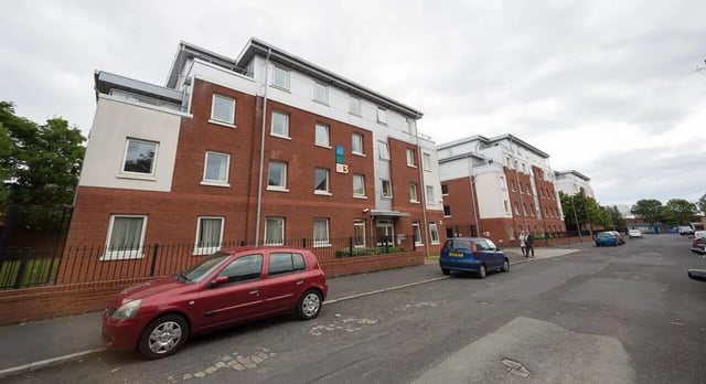 Red car parked outside student accommodation exterior at Q3 Apartments in Manchester Student Accommodation
