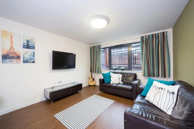 Leather sofas television artwork and guitar living room at Aspect 3 Apartments in Sheffield Student Accommodation