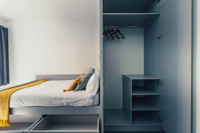 Bed with yellow throw and pillows wardrobe bedroom at Pennine House Leicester in Leicester Student Accommodation