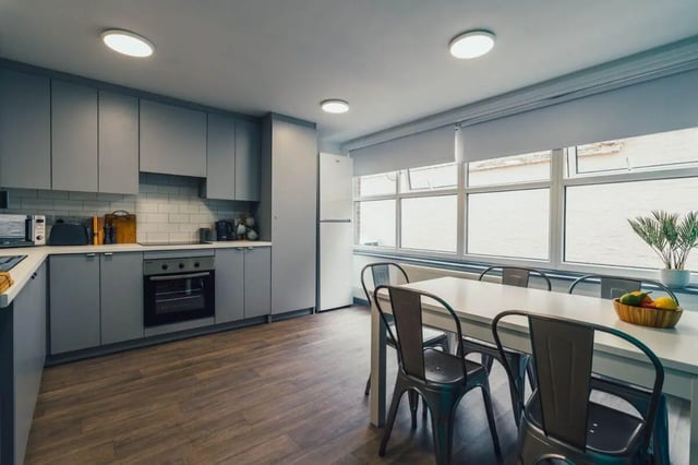 Grey cabinets oven dining table chairs kitchen at Pennine House Leicester in Leicester Student Accommodation