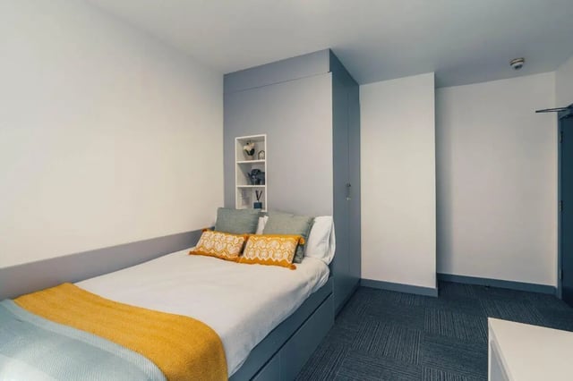 Bed with yellow blanket and pillows built-in wardrobe bedroom at Pennine House Leicester in Leicester Student Accommodation