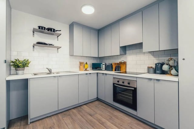 Modern grey cabinets sink oven microwave and stovetop kitchen at Pennine House Leicester in Leicester Student Accommodation