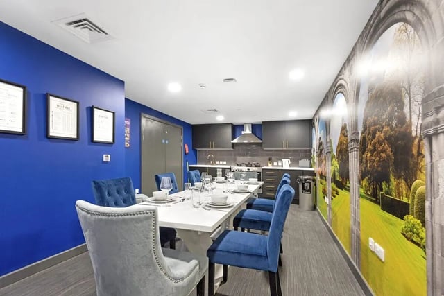 Dining table with blue chairs and kitchen communal area at Stanhope House Portsmouth in Portsmouth Student Accommodation