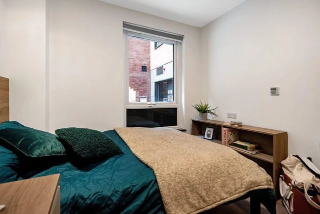 Bed with green pillows and tan blanket bedroom at Coppergate Swansea in Swansea Student Accommodation