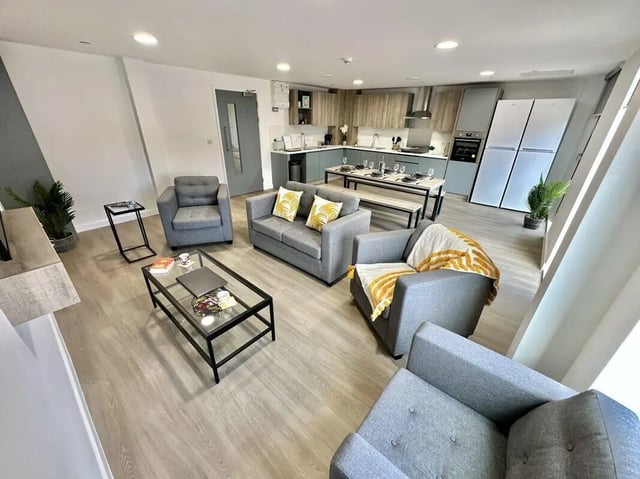 Modern living room with sofas dining table kitchen exterior at Albany Student Village in Coventry Student Accommodation