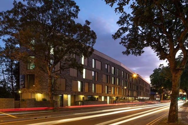 Modern brick building with many windows at dusk exterior at Graystacks in Nottingham Student Accommodation