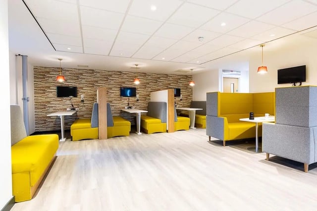 Study booths with yellow seating and TVs common area at Abbey House in Coventry Student Accommodation