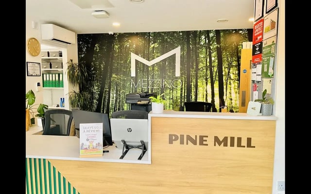 Reception desk with computers and forest mural reception area at Pine Mill in Lincoln Student Accommodation