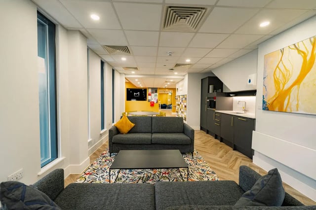 Grey sofas coffee table kitchen area living room at Hydrogen Falmouth in Falmouth Student Accommodation