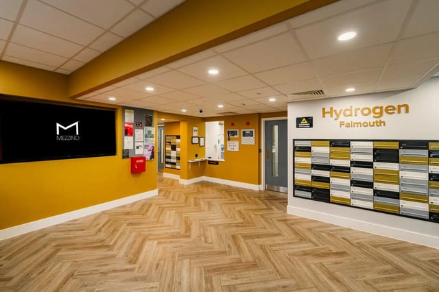 Mailboxes large screen and yellow walls reception area at Hydrogen Falmouth in Falmouth Student Accommodation