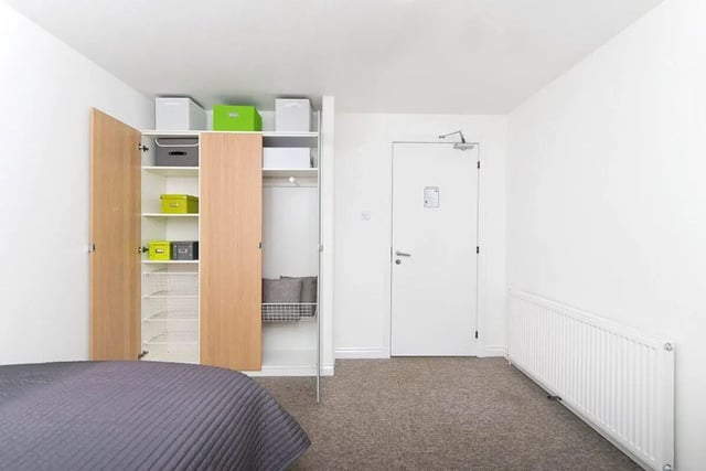 Open wardrobe with boxes grey bedding radiator bedroom at Froghall in Aberdeen Student Accommodation
