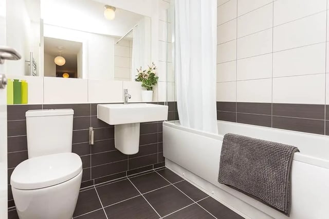 Toilet sink bathtub with towel and shower curtain Bathroom at Froghall in Aberdeen Student Accommodation