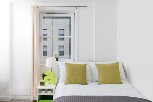 Bed with green pillows bedside lamp clock Bedroom at Froghall in Aberdeen Student Accommodation