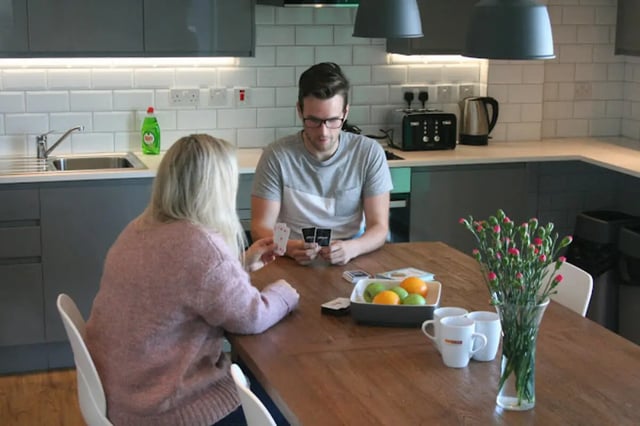 People playing cards at kitchen table kitchen at CityBlock Penny Street in Lancaster Student Accommodation