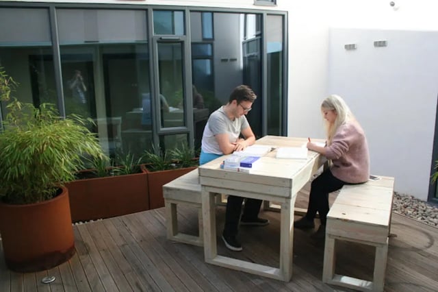 Students studying at outdoor picnic table with bench living room at CityBlock Penny Street in Lancaster Student Accommodation