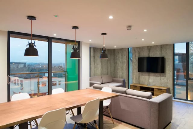 Dining table sofas television concrete walls living room at CityBlock Penny Street in Lancaster Student Accommodation