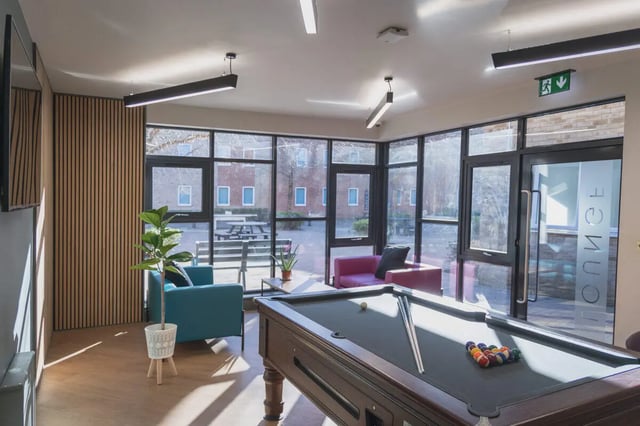 Pool table sofa chairs plant courtyard living room at The Park in Oxford Student Accommodation
