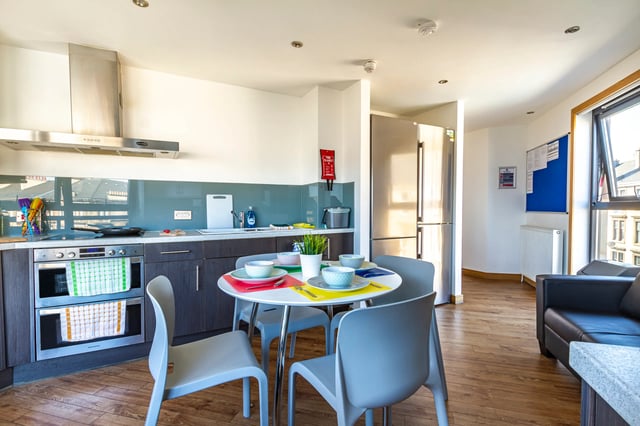 Kitchen with dining table refrigerator and sofa kitchen at Kaplan Living Glasgow - Argyle Street in Glasgow Student Accommodation