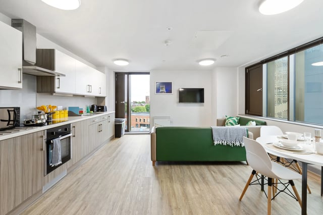 Kitchen dining area with green sofa living room at Kaplan Living Liverpool in Liverpool Student Accommodation