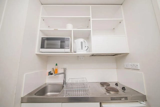 Microwave kettle sink stove and cabinets kitchen at The Collective at Columbia Apartments in Columbia Student Accommodation