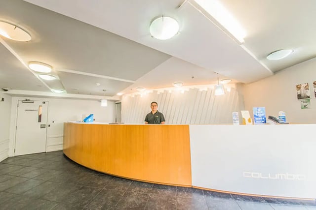Reception desk with staff and signs Lobby at The Collective at Columbia Apartments in Columbia Student Accommodation