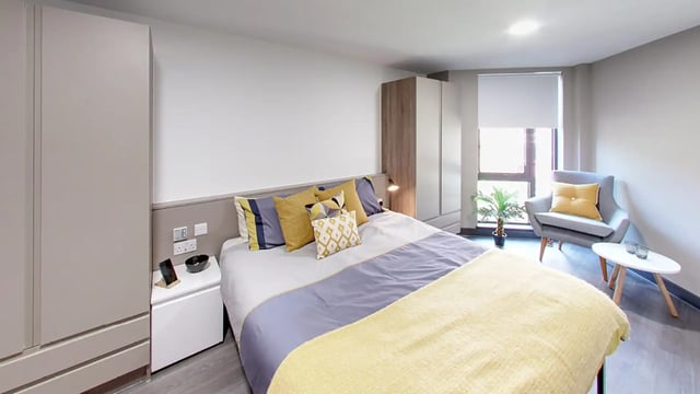 Bed pillows wardrobe chair and table bedroom at Sycamore House in Leeds Student Accommodation