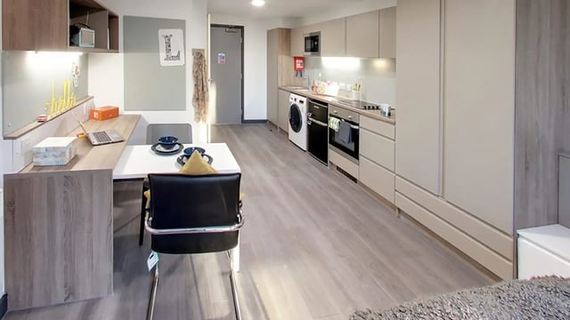 Table chairs desk kitchen appliances studio apartment at Sycamore House in Leeds Student Accommodation