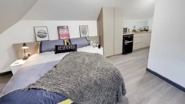 Bed with kitchen area and mini fridge bedroom at Sycamore House in Leeds Student Accommodation