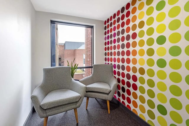 Two grey chairs colorful polka dot wall living room at Sycamore House in Leeds Student Accommodation