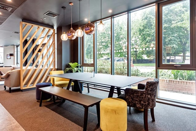 Dining table with benches chairs and ottoman common area at Trinity View Coventry in Coventry Student Accommodation